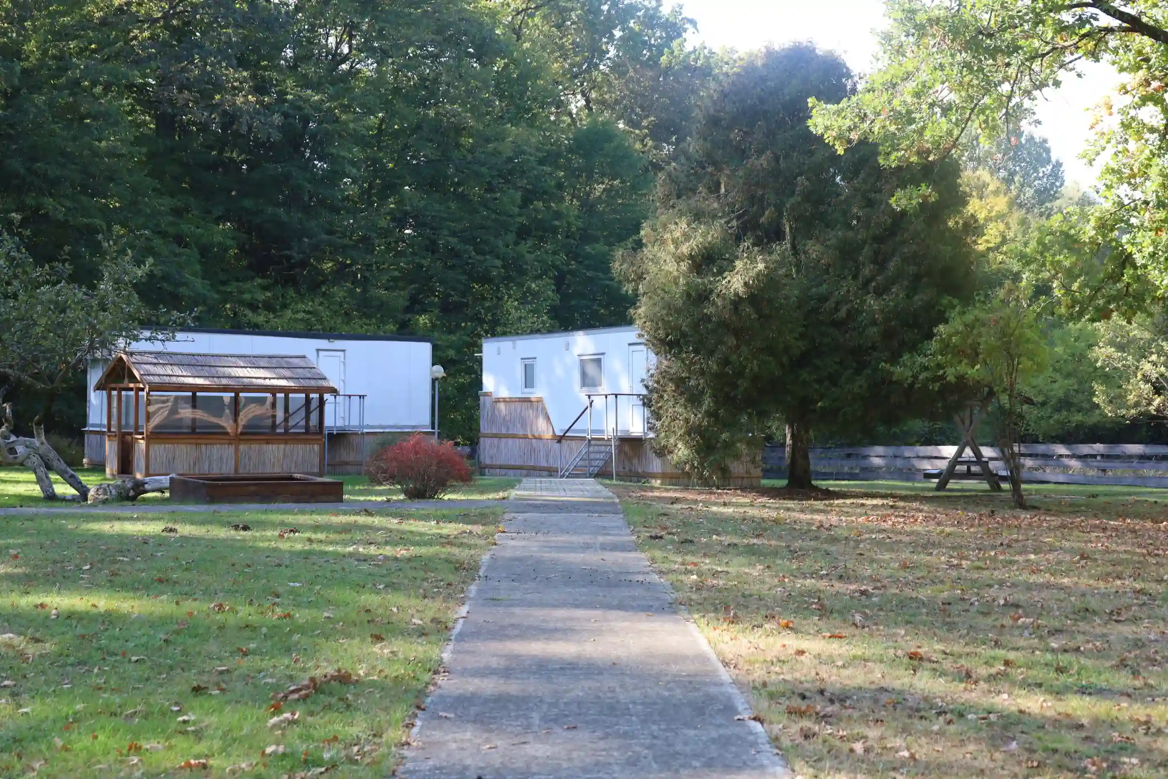 Дорога в кемпинг и уличная деревянная беседка с зоной для отдыха и мангалом на территории